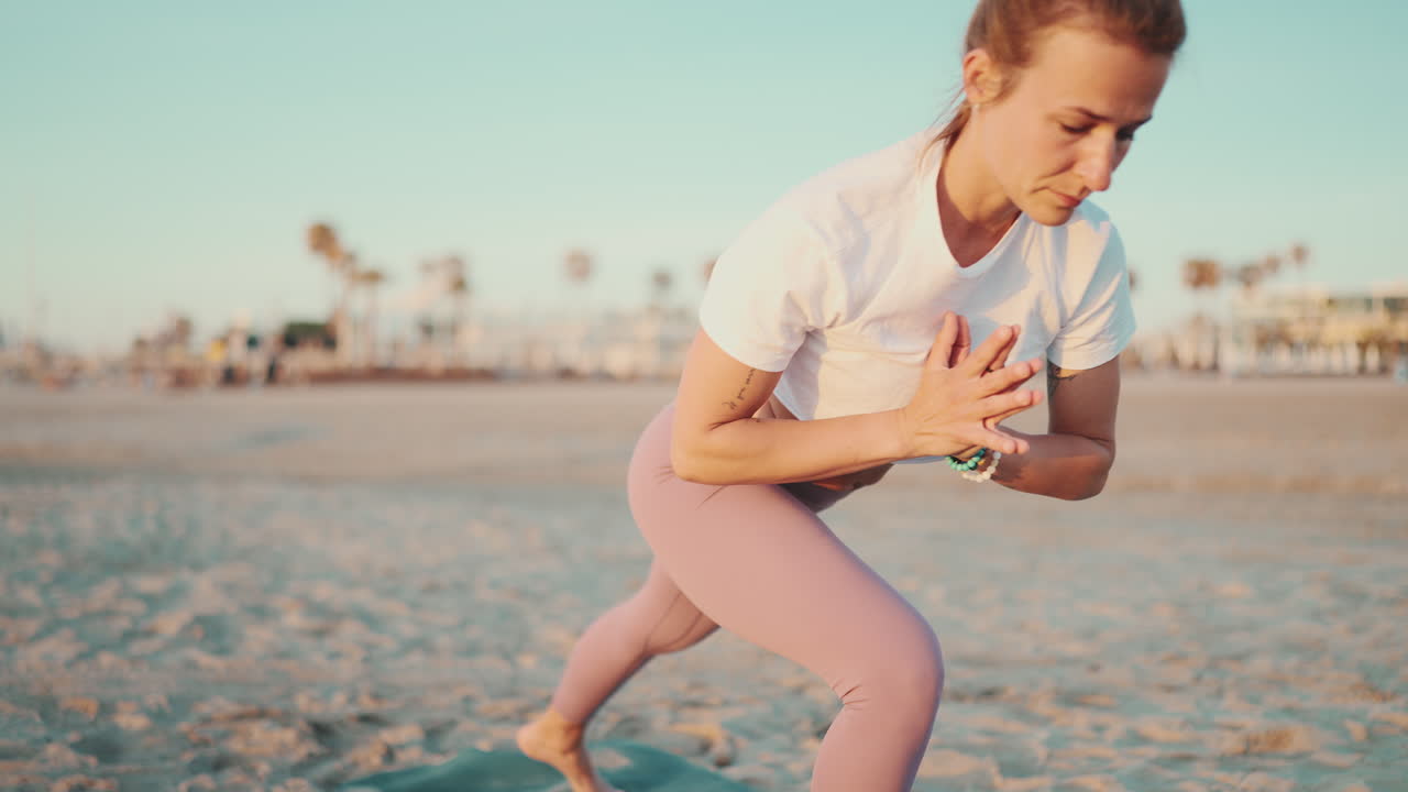 스포츠 옷을 입은 백인 여성이 야외에서 요가를 하고 있습니다.