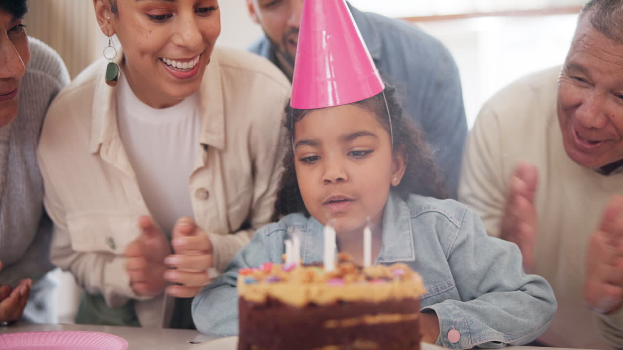 familia, niño y soplar en la vela con pastel