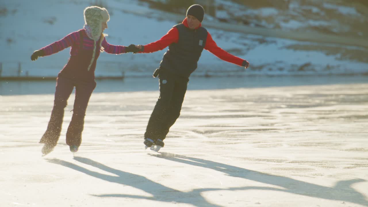 A Joyful Ice Skating Adventure: Two Enthusiastic Individuals Gliding Gracefully Across a Smooth Frozen Lake on a Sunny Day, Embracing the Joy of Winter Activities and Bonding Together in Nature's Wonderland