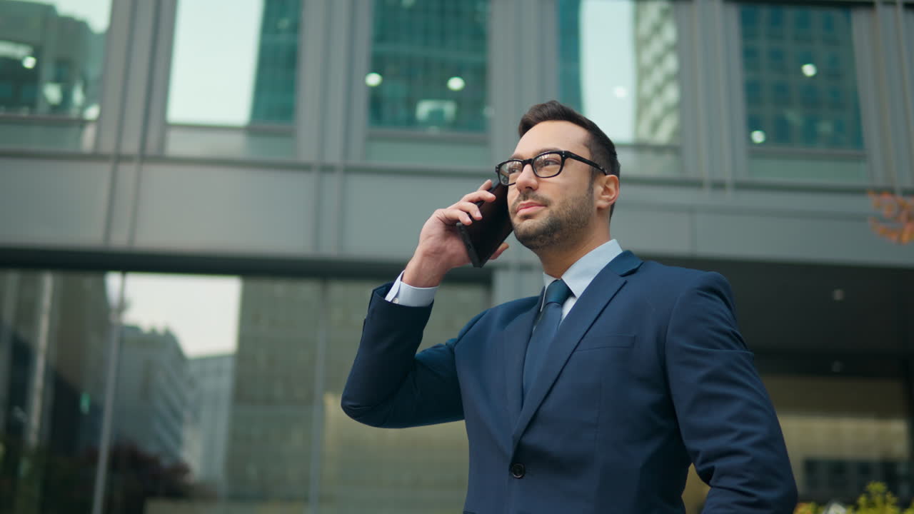 hombre de negocios hablando por teléfono fuera del edificio de oficinas