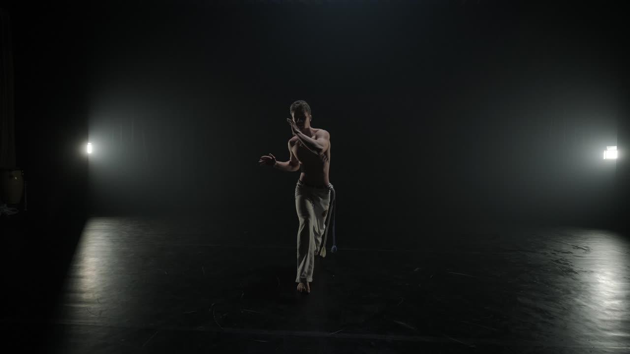 luchadores de capoeira realizando movimientos dinámicos en el escenario. artes marciales, danza y acrobacias en acción. atletas de pecho desnudo mostrando fuerza, flexibilidad y técnica bajo los reflectores