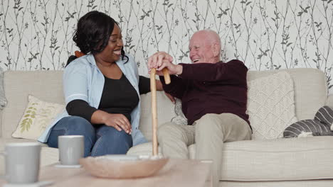 elderly man and caregiver laughing indoors