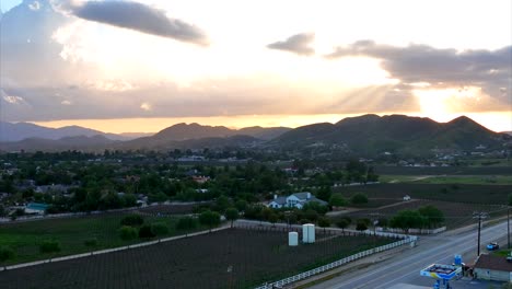 Vista-Aérea-De-La-Puesta-De-Sol-Sobre-Colinas-Y-Casas-En-El-Campo-De-California,-Ee.uu.