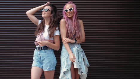 dos mujeres elegantes posando al aire libre