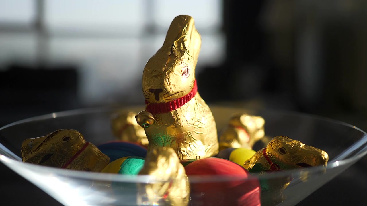 Golden Chocolate Easter Bunnies and Colorful Eggs in a Glass Bowl