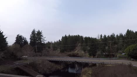 driving down 101 in oregon with a view of a curved road with a bridge going over a river