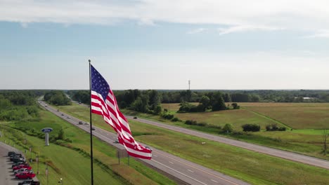 gorgeous 360 of usa flag with a highway and car dealership, rural scene, 4k drone