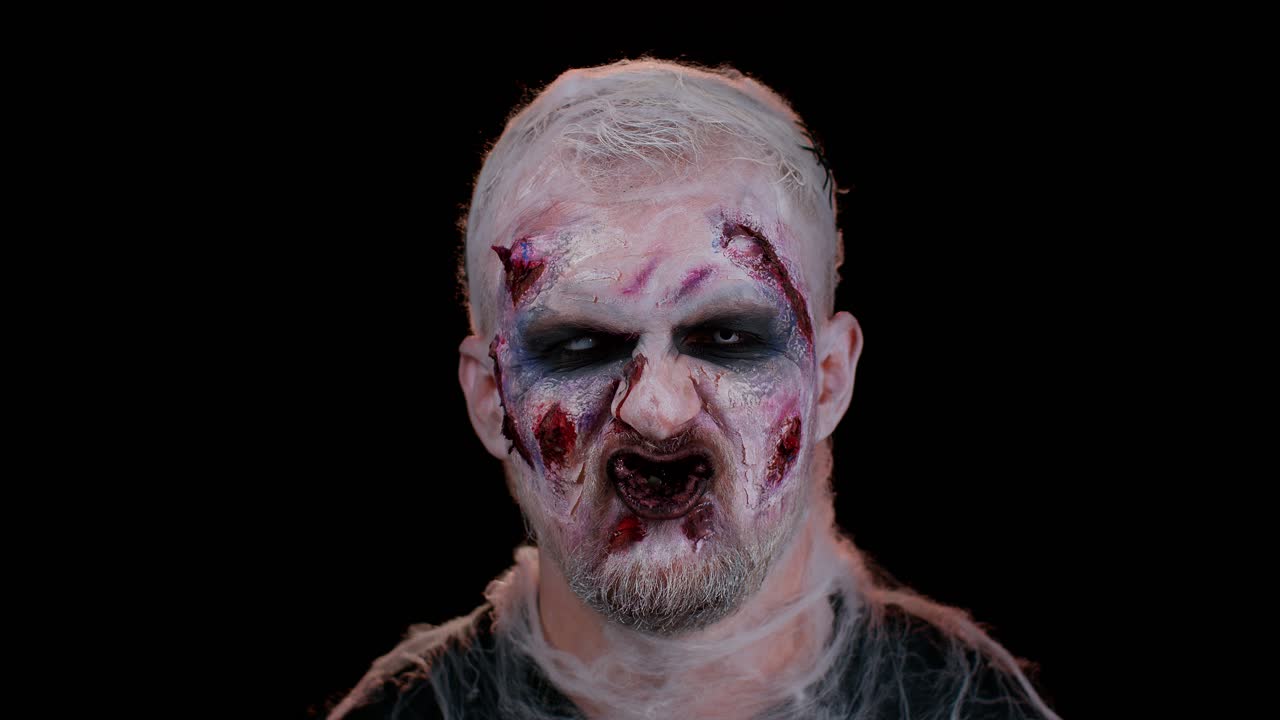 asustadizo herido no muerto halloween hombre zombie haciendo caras, sonriendo terriblemente, y chasqueando los dientes