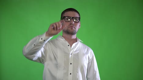 un hombre texturizado con cerdas y gafas controla sus manos con un holograma en un fondo verde