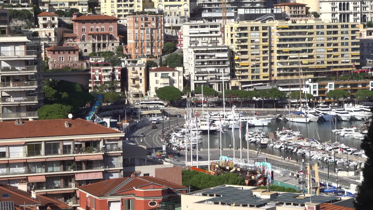 Monte Carlo, Monaco - July 4, 2025: View of buildings, high-rise towers, and bustling marina filled with luxury yachts, framed by the surrounding mountains