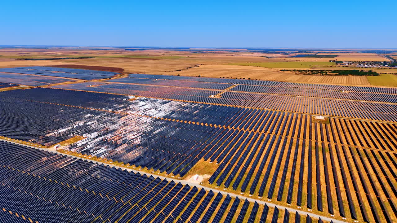 Vast field covered with multiple solar panels. Drone footage over the area used for accumulation of the energy of sun