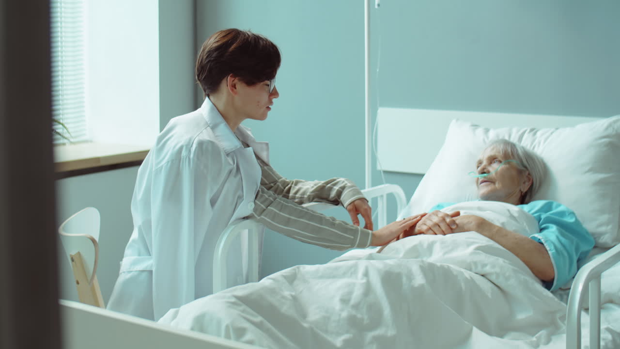 mujer que mantiene a una madre anciana enferma en la sala del hospital