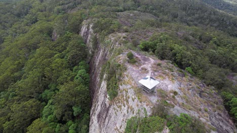 Mount Tinbeerwah Lookout With Fire Tower Perched On Steep Rocky Cliff. Tewantin National Park In Queensland. aerial pullback shot