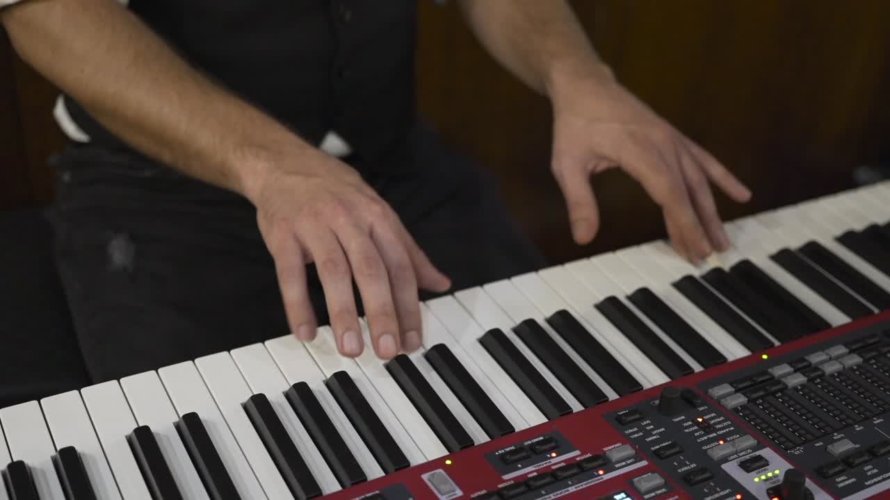 Close up of a musician's hands playing an electronic keyboard during a performance