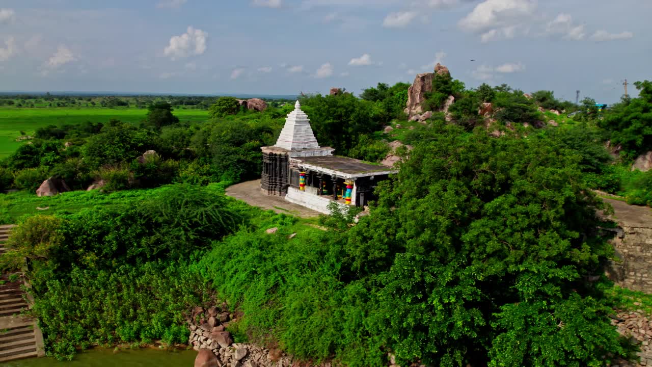 Temple from the Kakatiya period Thumbureshwara Devalayam at yelupu Gonda, Surampally, Tekmal, Telangana, india. day time, semi circle, drone shot, 4k.