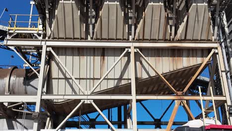 panning up shot revealing industrial equipment at wood processing plant