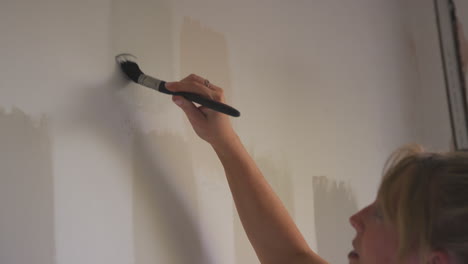 Close-Up-Of-Woman-Decorating-Room-In-House-Painting-Tester-Paint-Colour-Strips-On-Wall