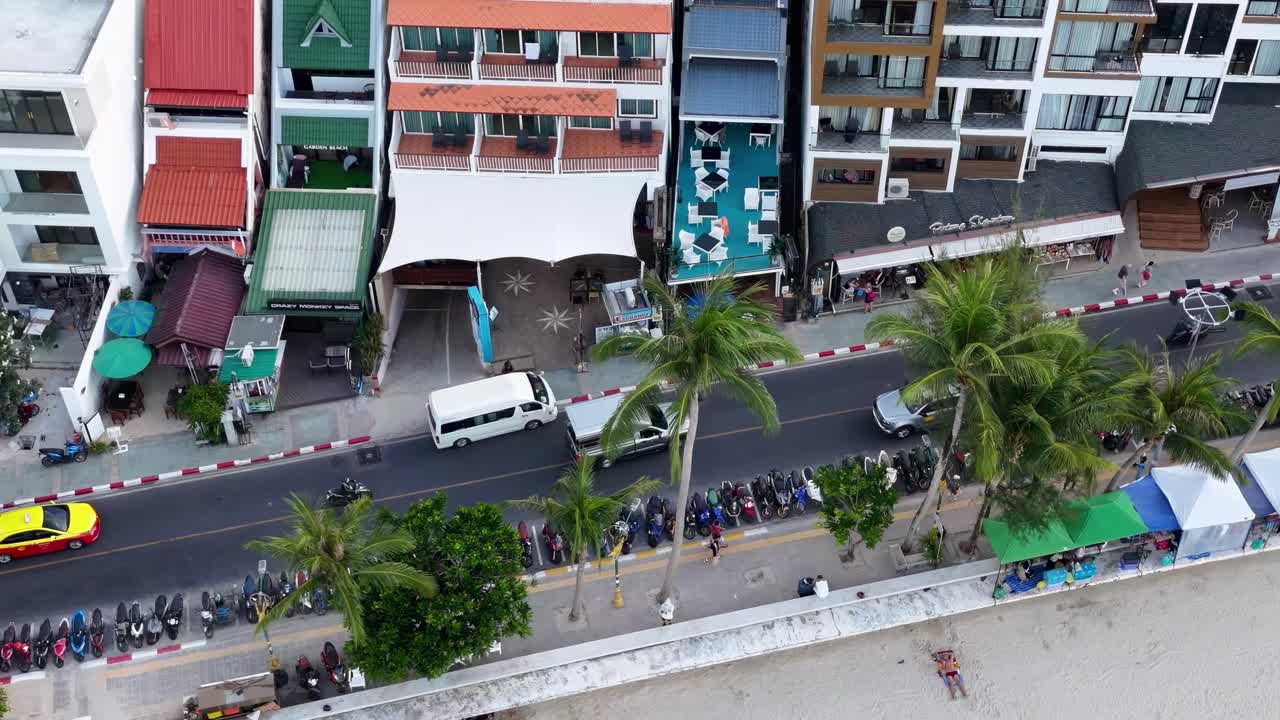 Aerial footage captures vibrant beachfront buildings and bustling street activity in Patong, Phuket, showcasing colorful architecture and lively atmosphere