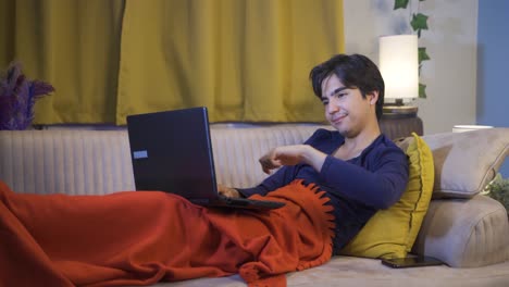 Unhappy-man-using-laptop-lying-down.