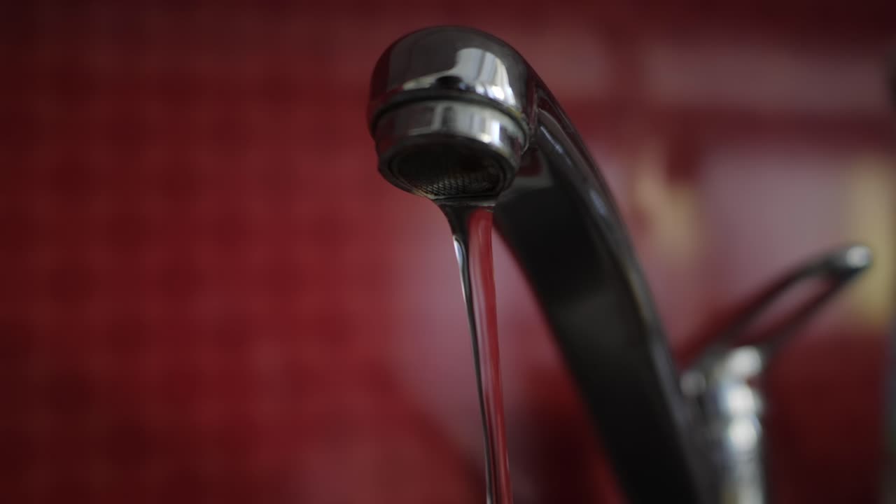 fregadero tirando agua en una cocina roja