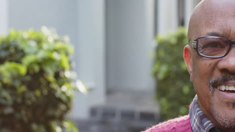 Half-portrait-of-senior-african-american-man-in-glasses-smiling-in-garden,-copy-space,-slow-motion