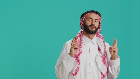 Muslim-man-holds-fingers-crossed