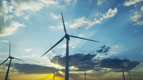 turbinas eólicas de pie al atardecer. granja con turbinas eólicos. generando energía limpia y renovable. poniendo el sol de color naranja brillante. energía alternativa