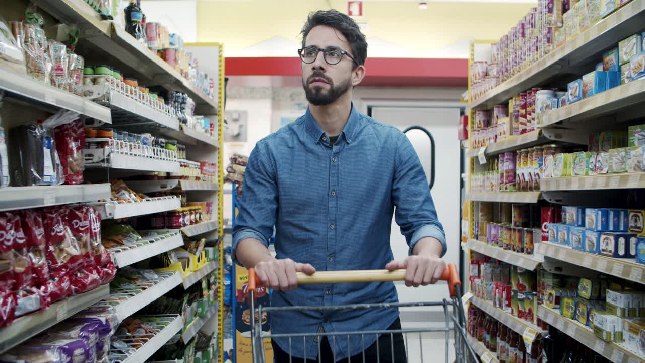 Uomo serio che acquista prodotti in negozio