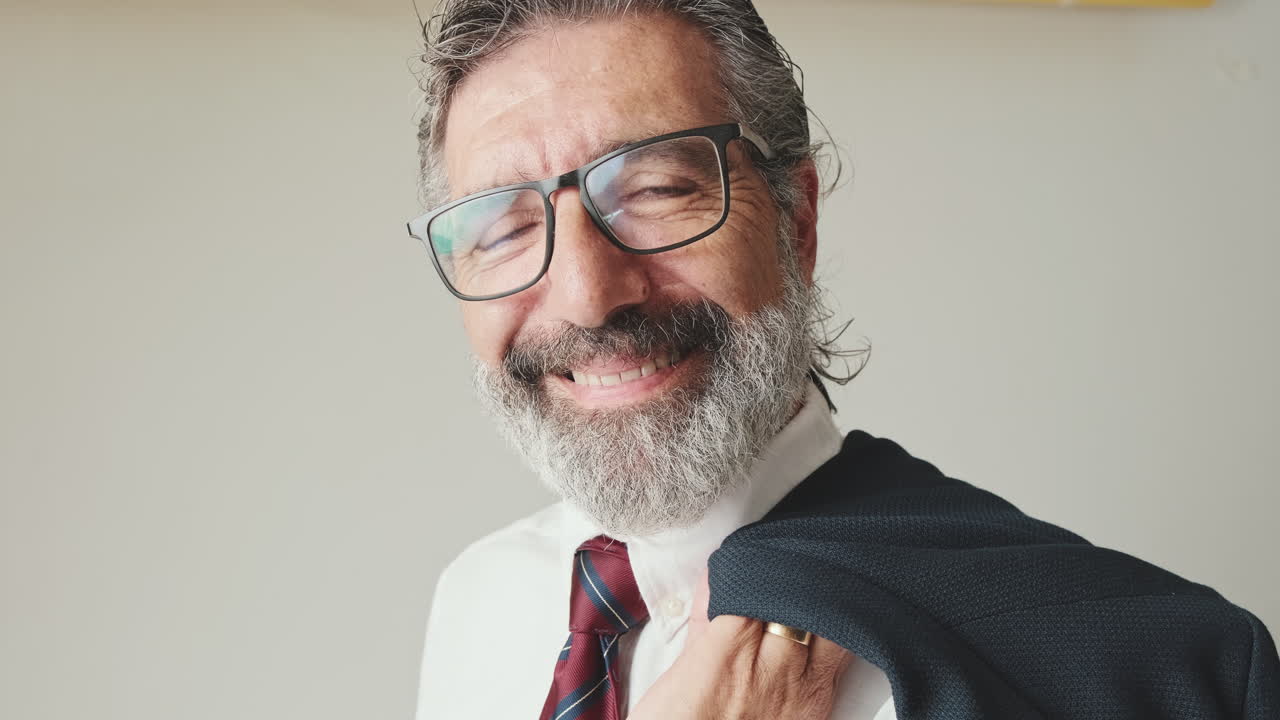 Uomo d'affari maturo sorridente con gli occhiali che guarda la fotocamera