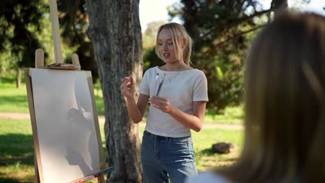 young woman teaching painting outdoors