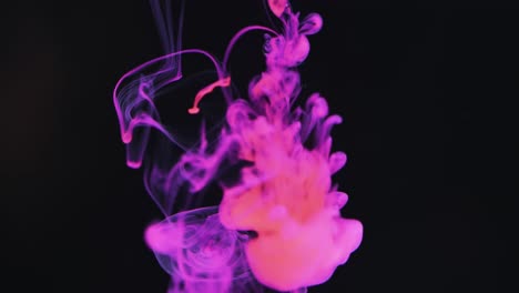 Slow-motion-video-of-purple-watercolor-ink-mixing-in-water-against-black-background
