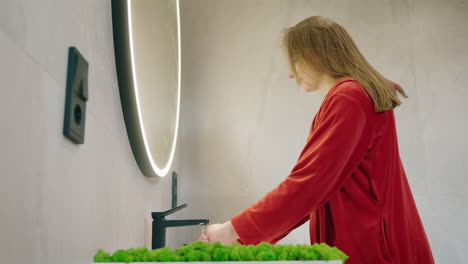 woman washing hands in modern bathroom