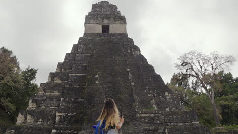 tourist woman turn to watch tikal pyramid temple i guatemala. solo traveler. independent slow motion