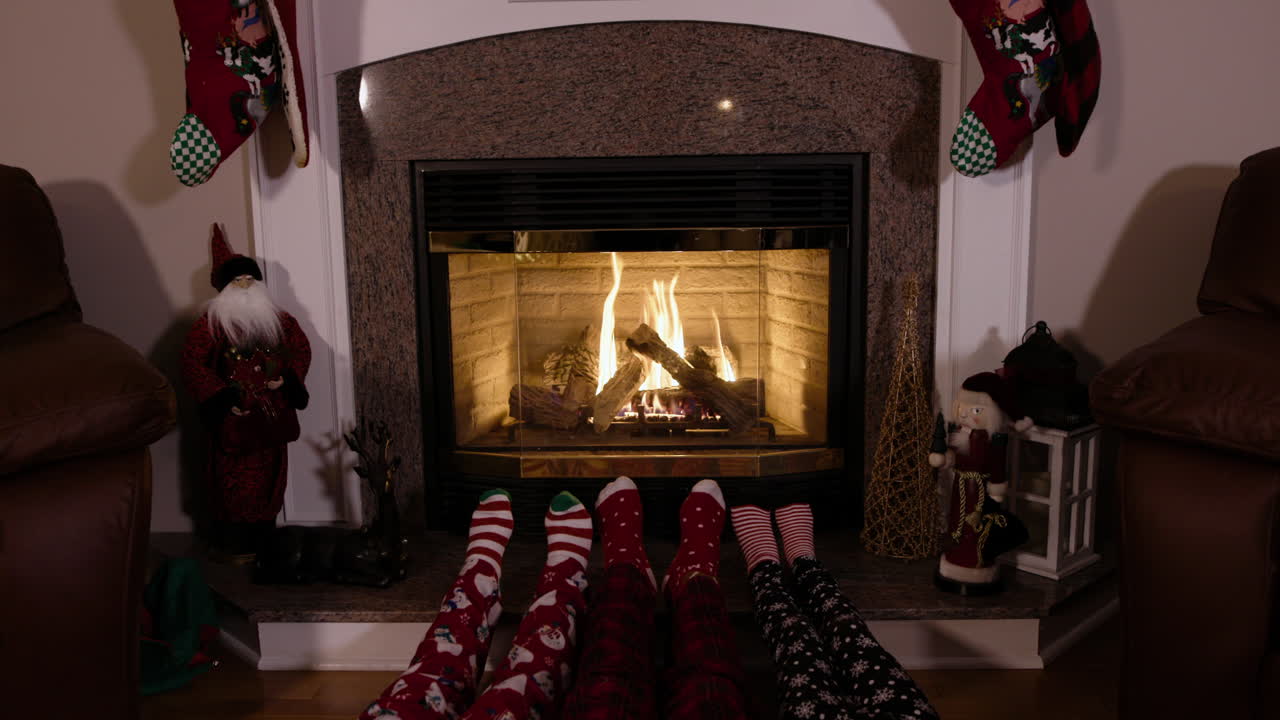불 옆에서 크리스마스 양말을 신은 아이들의 발