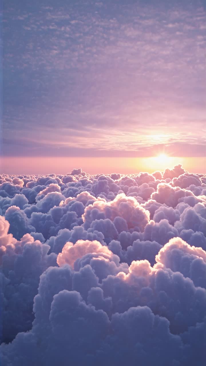 Vista aerea di nuvole soffici bagnate in tonalità rosa e viola all'alba, creando un'atmosfera sognante ed eterea