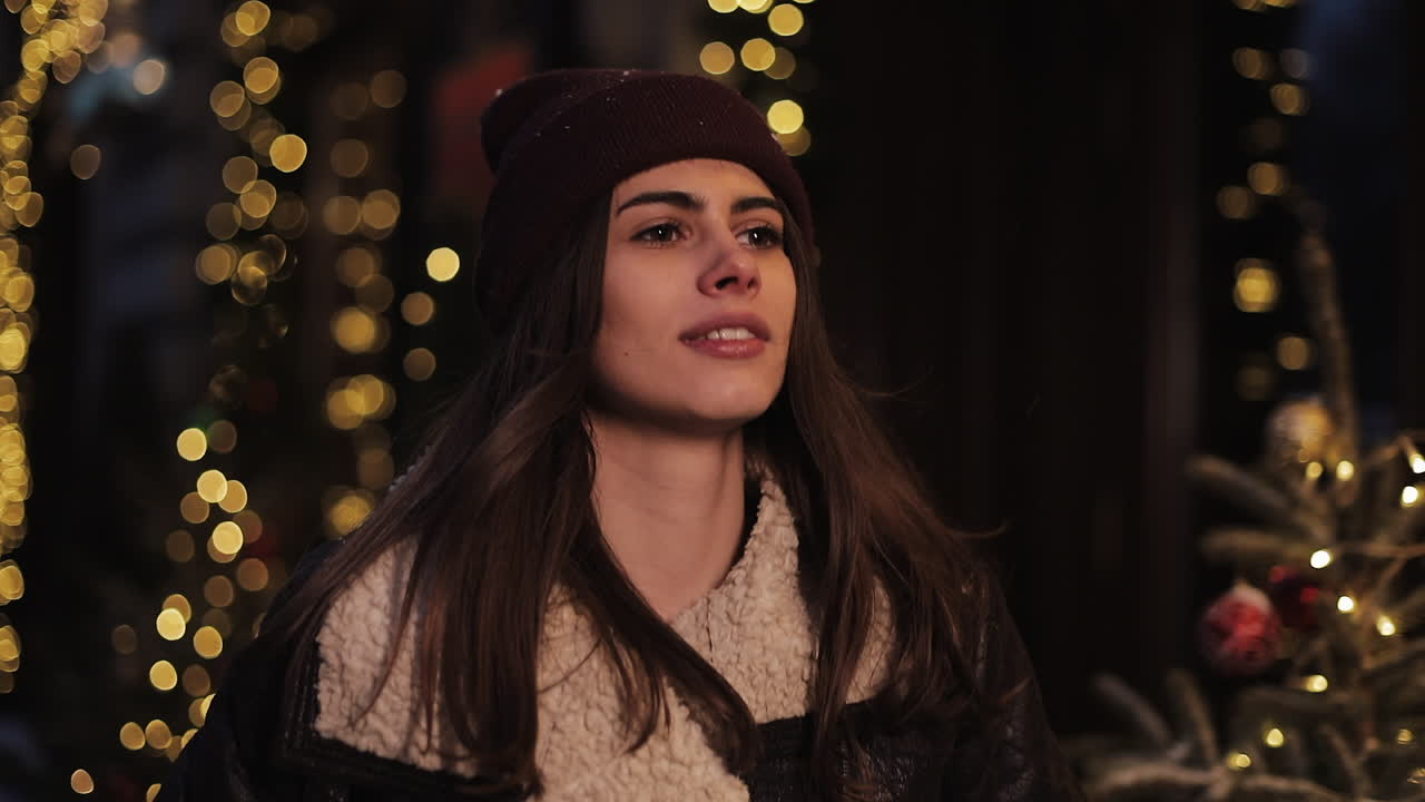 Donna con berretto davanti alle luci di Natale