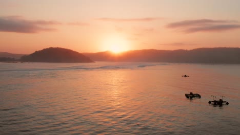 Sonnenaufgang-An-Den-Surfspots-Von-Gerupuk-In-Lombok,-Mit-Blick-Auf-Die-Bucht-Mit-Den-Fischerbooten-Und-Surfern