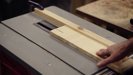 High-angle-footage-of-cutting-wooden-board-on-saw-machine.-Action.-Industrial-machine-with-circular-saw-cuts-wooden-board.-Woodworking-shop,-working-at-machine-on-cutting-of-wood