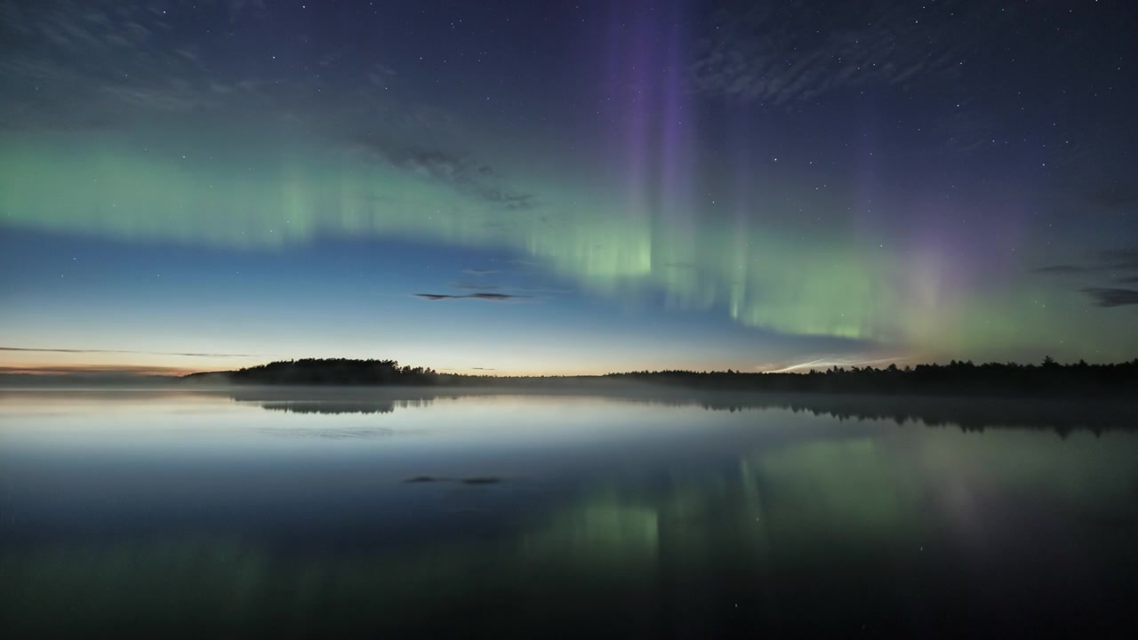 Time-lapse dell'aurora boreale riflessa su un lago calmo