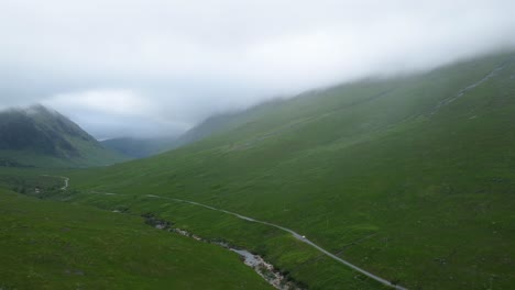 Van-Fährt-Auf-Einer-Abgelegenen-Straße-In-Einer-Grünen-Bergkette-Davon