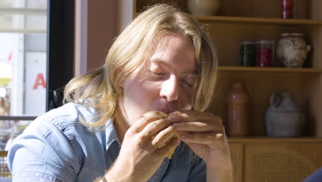 hombre rubio comiendo pizza con amigos en el restaurante