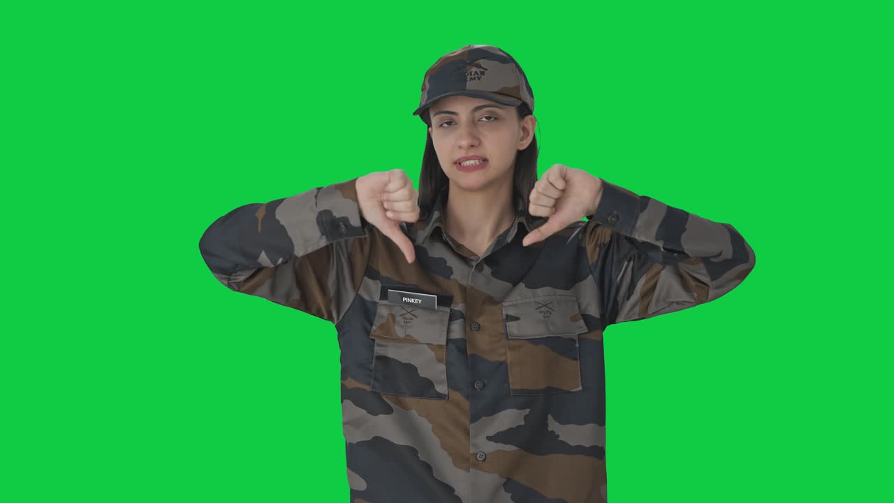 разочарованная индийская женщина-армейский офицер показывает пальцы вниз зеленый экран