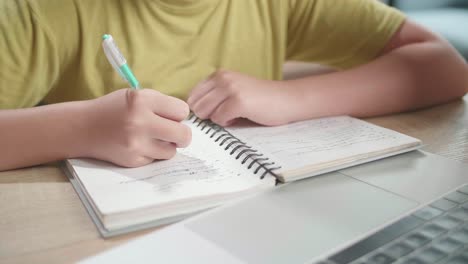 close up of hand's young girl writing in the notebook