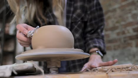 woman creating pottery on a wheel