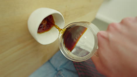 first-person view pouring coffee into a white mug, dynamic angle