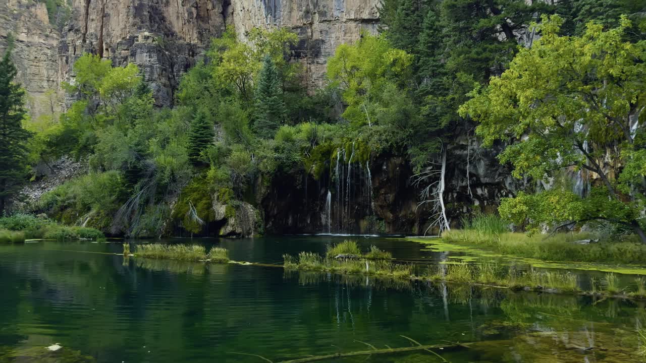 Hanging Lake reflecting forest and cliffs in Glenwood Canyon, Colorado, establishing pan
