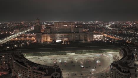 hiperlapso aéreo del parlamento rumano en bucarest por la noche - coches circulando por la carretera - disparo en órbita