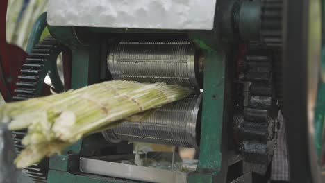 close-up von einem straßenverkäufer, der zuckerrohr in bangalore, indien, zerkleinert