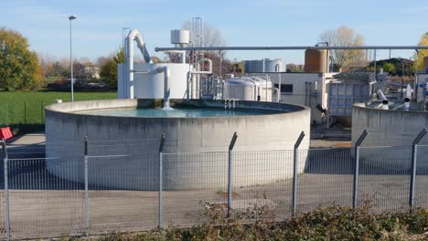 große kreisförmige industriebehälter im freien mit laufendem wasserhahn in langsamer bewegung