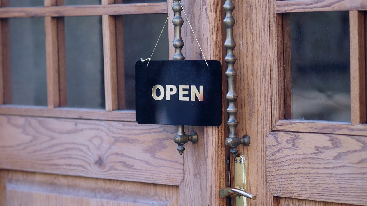 Black Open Sign Hanging on a Classic Wooden Door